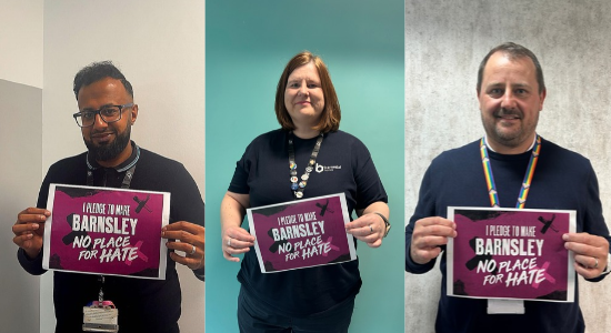 Colleagues holding up the Hate Crime Awareness Week pledge. 
